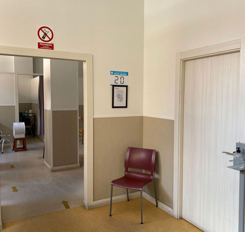 Imagen de entrada con silla de espera de color granate a la derecha